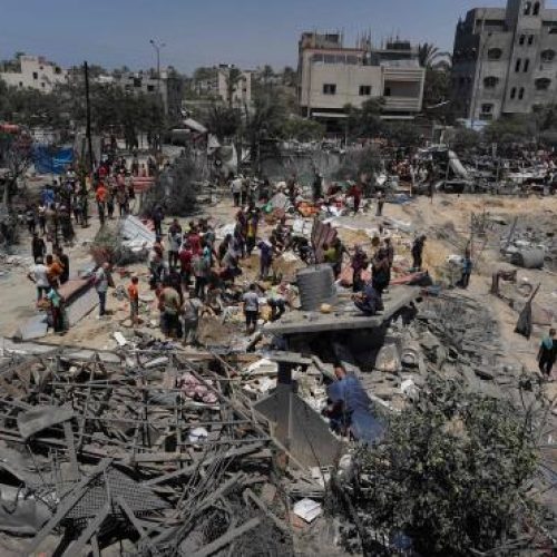 TOPSHOT - Palestinians look at the debris of destroyed tents and make shift housing structures following an Israeli military strike on the al-Mawasi camp for internally displaced people (IDP), near the city of Khan Yunis, southern Gaza Strip on July 13, 2024, in which killing 71 people were killed.    Al-Mawasi had been declared a safe zone by Israel as it pursues its military offensive in other parts of the Gaza Strip in response to the October 7 Hamas attacks. (Photo by Bashar TALEB / AFP)